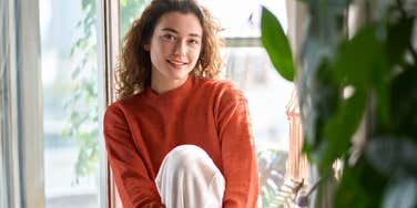 positive woman after banishing negative energy from her home