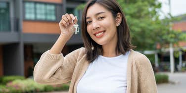 Gen Z woman holding up keys to her new home