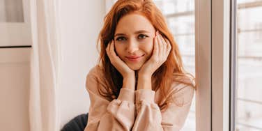 classy woman sitting in her home by the window