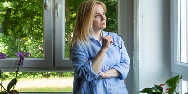 woman looking at trees out window