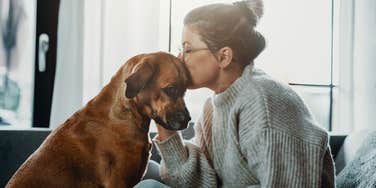 dog owner with specific personality traits cuddling with dog