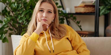 serious woman sitting on couch in living room