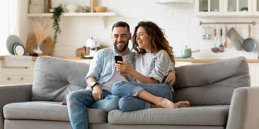 happy couple texting on phone together