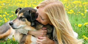 Woman hugs dog.