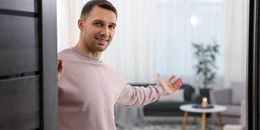 young gen z man welcoming boomer parents into his home
