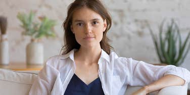 middle class woman sitting in living room unable to afford more