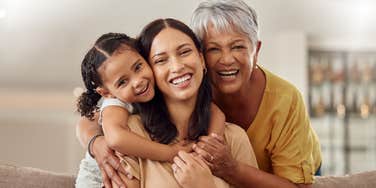 grandmother, mom, and daughter hugging 