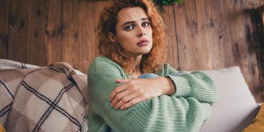 introverted woman sitting at home upset about her love life
