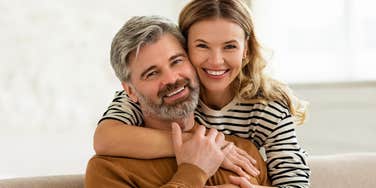 woman hugging man from behind lovingly