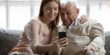 bride and her grandpa watching a video of him walking in the driveway