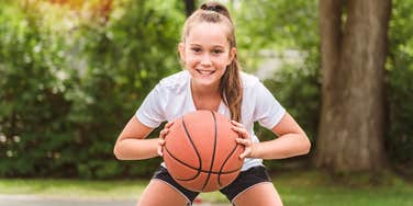 young female athlete playing basketball