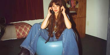 90s girl sitting on inflatable furniture in her room millennials