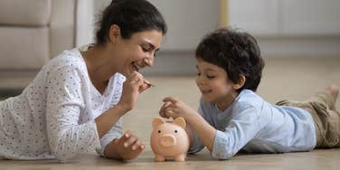 mom teaching son to save money in a bank