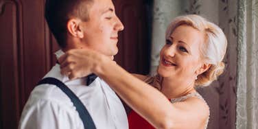 groom's mother helping him get dressed