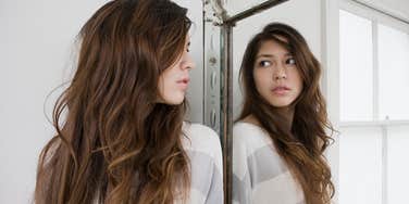insecure woman looking in mirror