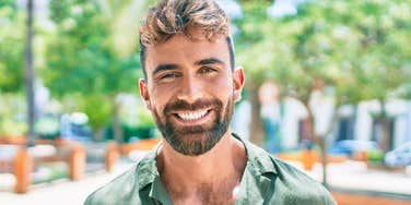 good man smiling standing outside
