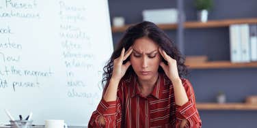 stressed teacher sitting in classroom