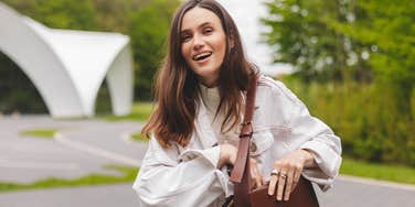 smiling frugal woman holding a purse