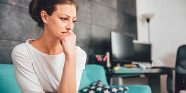 upset and depressed woman sitting on couch