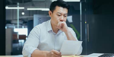 Worker looks stressed while reading.