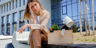 upset employee sitting outside of office after getting fired