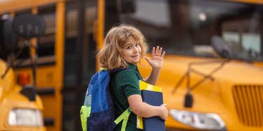 student about to hand a note to their school bus driver