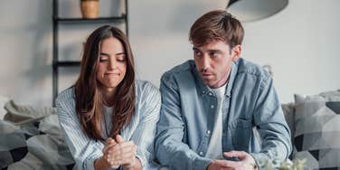 young couple arguing on couch at home