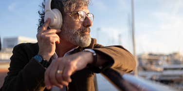 older man listening to music with headphones