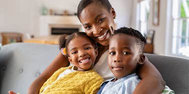 wealthy mother smiling with her kids on the couch