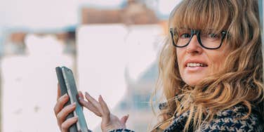 older woman looking through texts on her phone