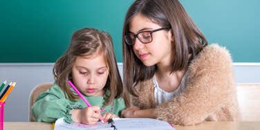 teen girl mentoring a toddler