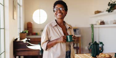 woman smiling while drinking coffee in kitchen