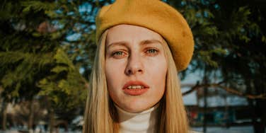 sad unhappy woman standing outside in beret