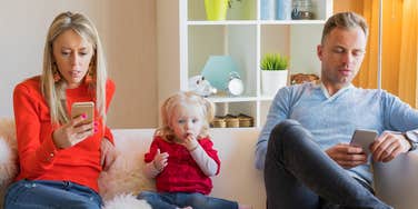 parents looking at their phones ignoring their child