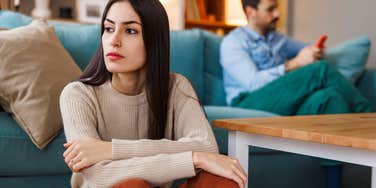 woman annoyed by husbands behavior looking upset