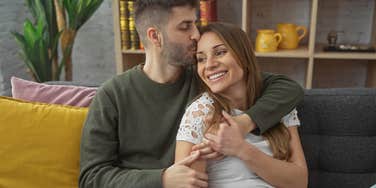 man deeply in love with woman kissing her head gently