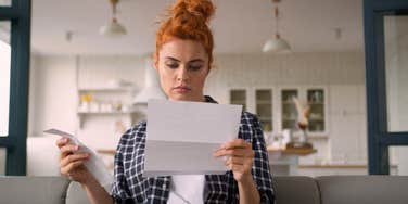single woman worried about money looking at bill and receipt