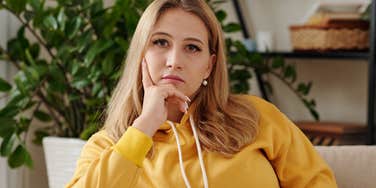 serious woman sitting alone on her couch