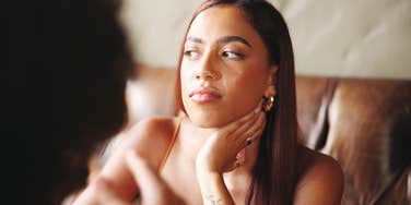 woman sitting with friend looking uninterested in conversation