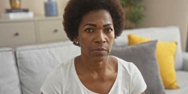 stressed sad serious woman sitting on her couch at home