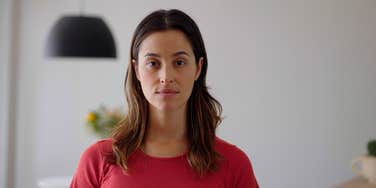 serious woman standing at home looking at camera