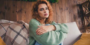 woman sitting on her couch struggling emotionally