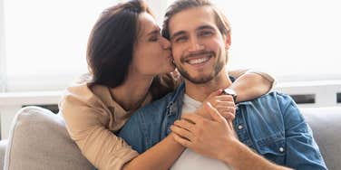 happy wife kissing her loving husband on the cheek