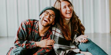 Playful couple laughing together, illustrating ways the most romantic couples keep their marriage full of sparks