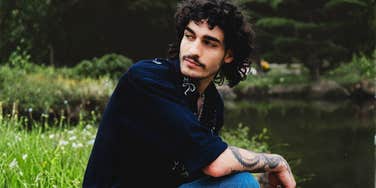 Man sitting contemplatively by a calm lake, illustrating the need for a personal space to process tears and emotions over the years