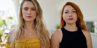 two new friends unsure of each other standing side by side