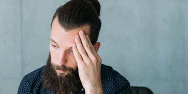 Upset unemployed young man thinking hard.