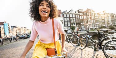 happy woman riding a bike on the streets of Europe