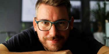 Warm confident man smiling indoors showing the art of being a decent husband.