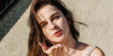 Flirty woman blowing a kiss, illustrating subtle body language tricks that naturally drive attraction and chemistry